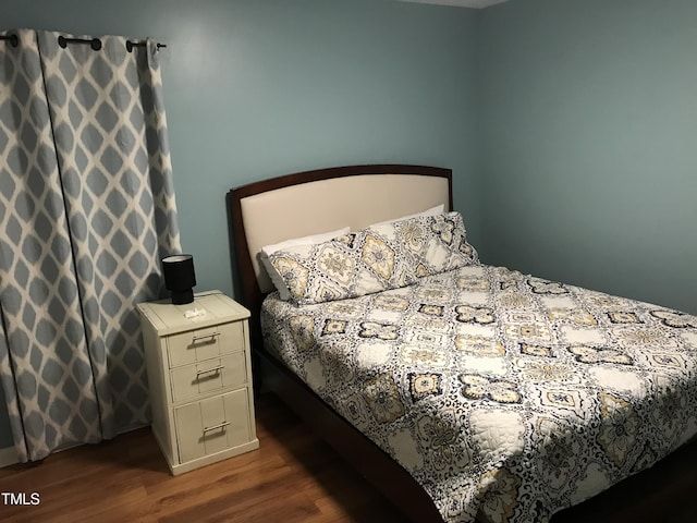 bedroom with dark wood-type flooring