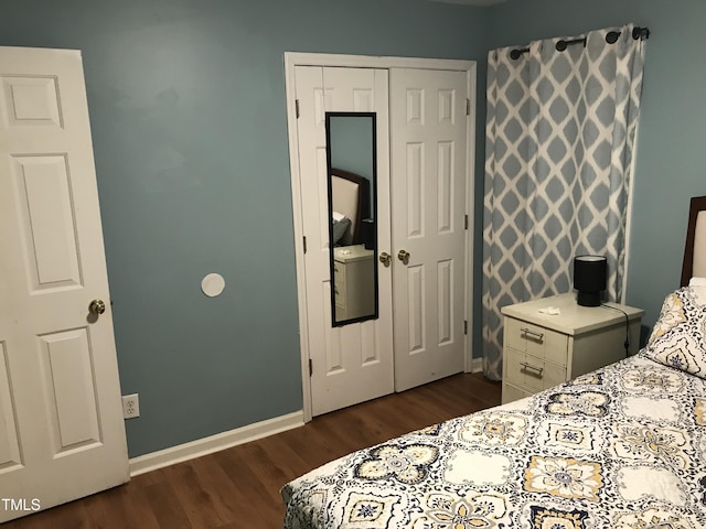 bedroom featuring dark wood-style floors, a closet, and baseboards