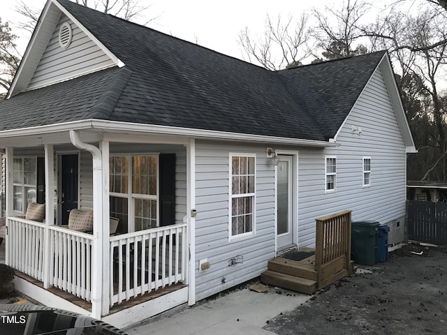 back of property featuring roof with shingles