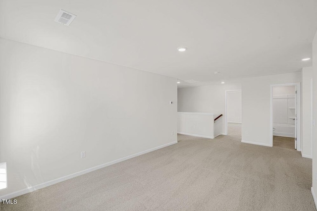 unfurnished room featuring light carpet, baseboards, visible vents, and recessed lighting