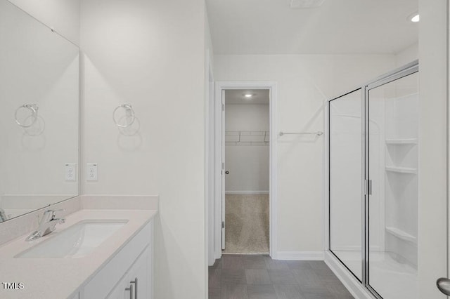 full bath with a stall shower, a spacious closet, and vanity