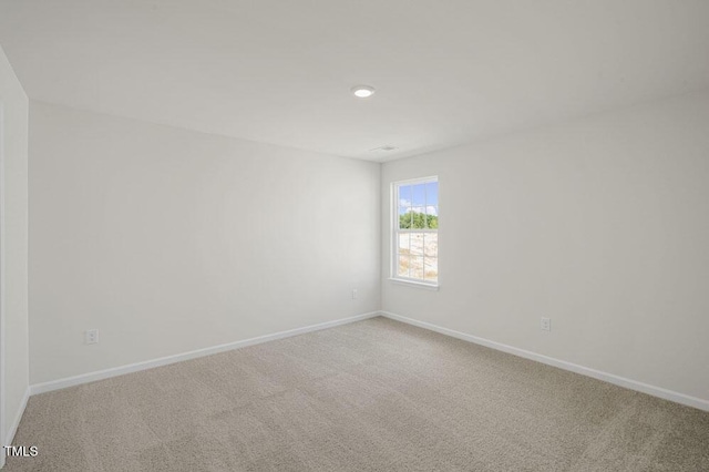 unfurnished room featuring carpet and baseboards