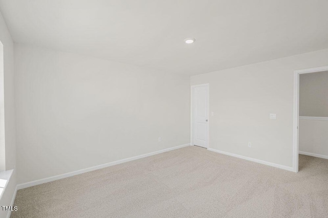 spare room featuring baseboards, recessed lighting, and light colored carpet