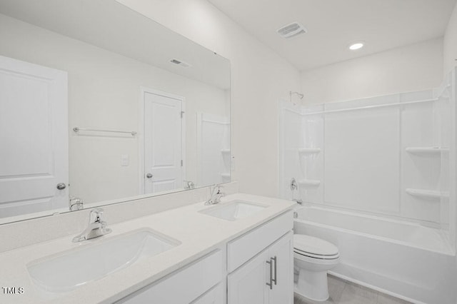 full bath with toilet, double vanity, a sink, and visible vents