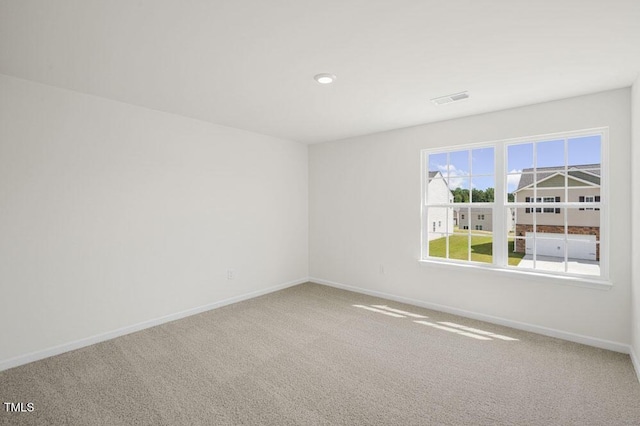 unfurnished room featuring carpet floors, visible vents, and baseboards