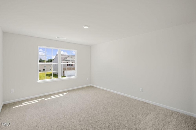 unfurnished room featuring carpet and baseboards