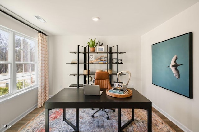 office area featuring visible vents, baseboards, and wood finished floors