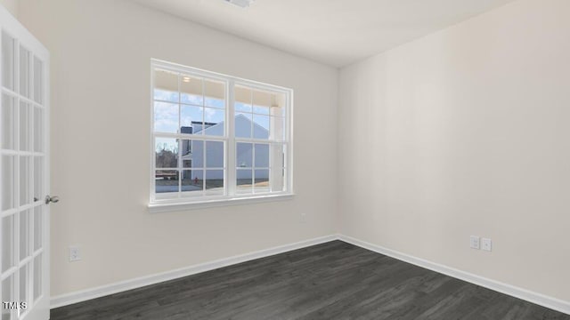 unfurnished room with dark wood-style floors and baseboards