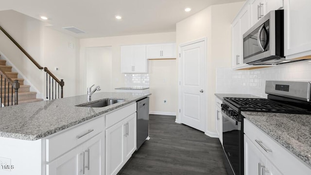 kitchen featuring dark wood-style floors, appliances with stainless steel finishes, a sink, and white cabinets