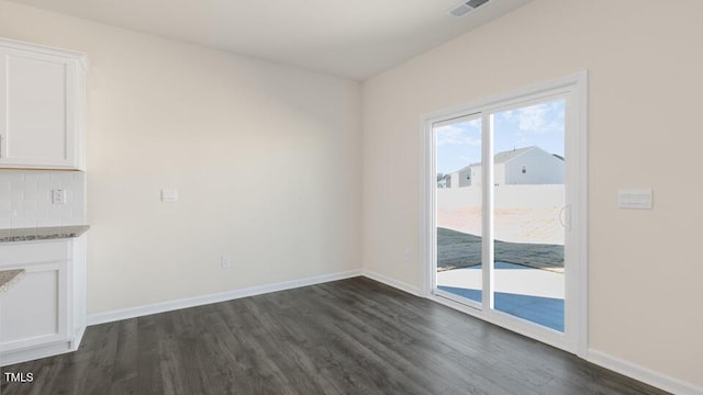 interior space featuring dark wood-type flooring, visible vents, and baseboards