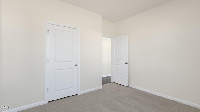 unfurnished bedroom with light carpet and baseboards