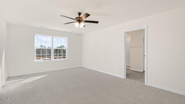 empty room with ceiling fan, baseboards, and light colored carpet