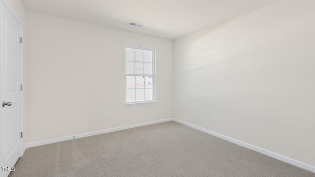 unfurnished room featuring carpet, visible vents, and baseboards