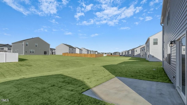 view of yard with a residential view, fence, and a patio