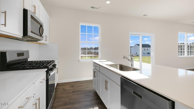 kitchen featuring dark wood-style flooring, light countertops, visible vents, appliances with stainless steel finishes, and a sink