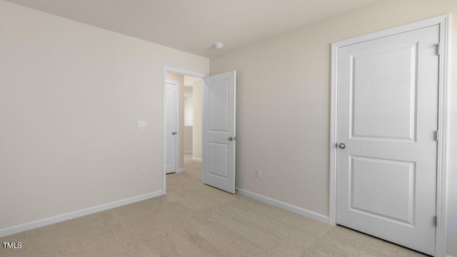 unfurnished bedroom with light carpet and baseboards