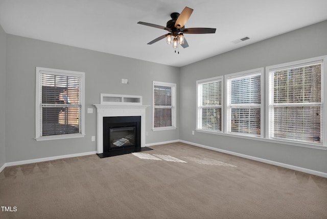 unfurnished living room featuring a fireplace with flush hearth, carpet, and baseboards