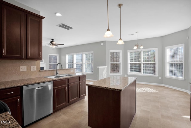 kitchen with light stone counters, a sink, visible vents, stainless steel dishwasher, and decorative backsplash