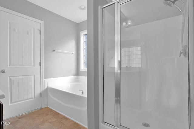 bathroom with a stall shower and a garden tub