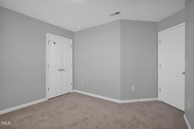 unfurnished bedroom featuring carpet floors, visible vents, and baseboards