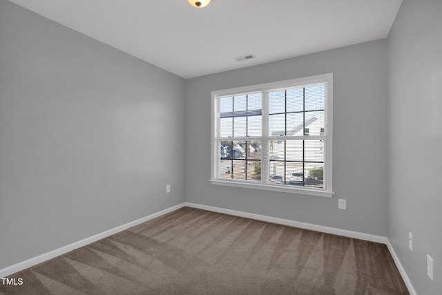 unfurnished room featuring carpet flooring, visible vents, and baseboards