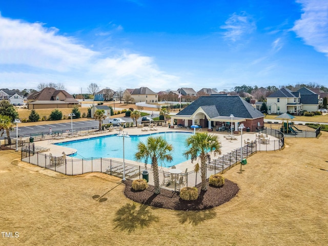 pool with a residential view, a patio area, and fence