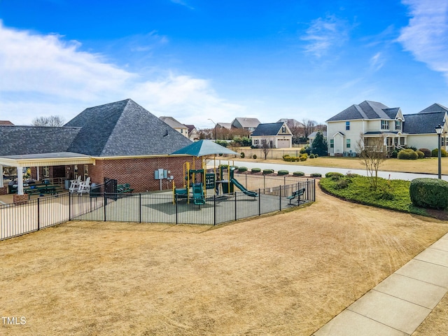 view of home's community featuring playground community, fence, and a residential view