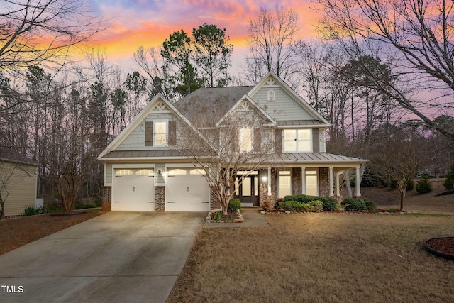 craftsman inspired home featuring driveway, a garage, metal roof, a standing seam roof, and brick siding