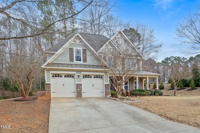 view of front of house featuring a garage, a standing seam roof, concrete driveway, and brick siding