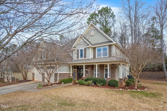 view of front of property with driveway, an attached garage, covered porch, a front lawn, and brick siding