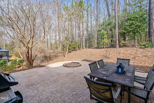 view of patio featuring outdoor dining area and a fire pit