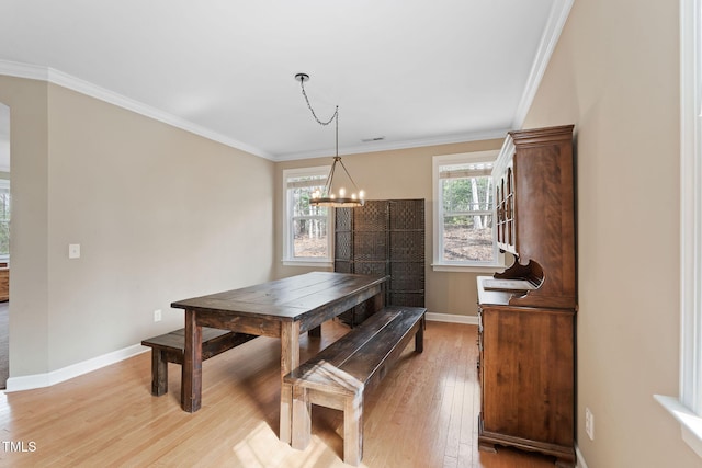 dining space featuring crown molding, light wood-style flooring, baseboards, and an inviting chandelier