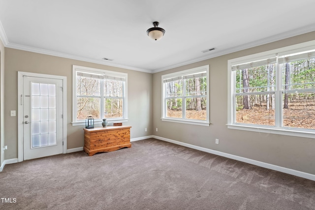 carpeted empty room featuring visible vents, crown molding, and baseboards