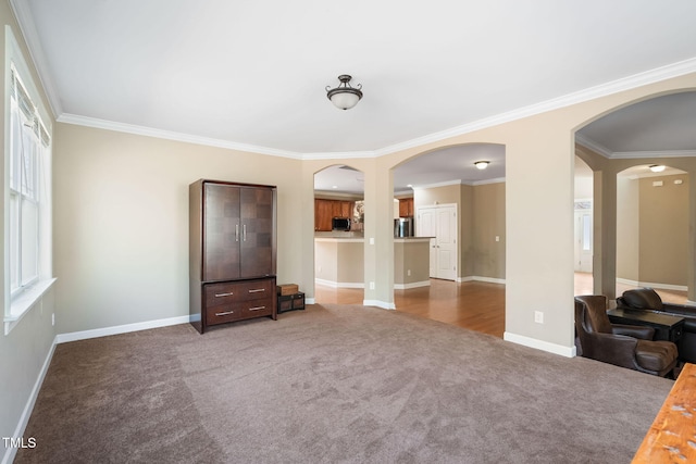 interior space featuring arched walkways, baseboards, and crown molding