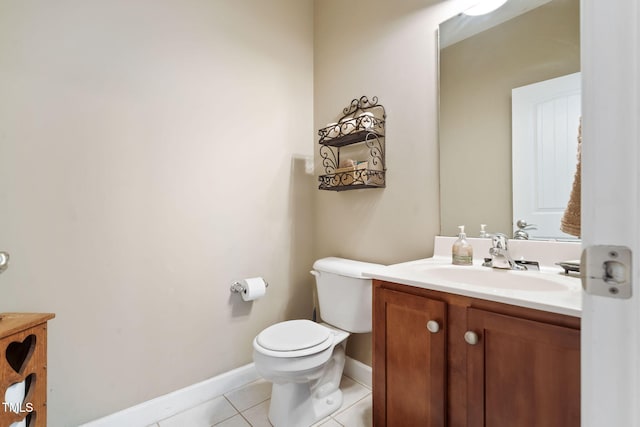 bathroom with toilet, vanity, baseboards, and tile patterned floors