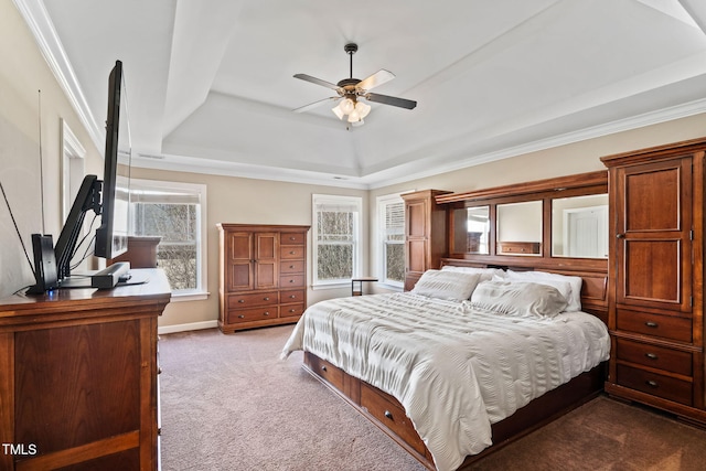 bedroom with a tray ceiling, carpet flooring, ceiling fan, and baseboards