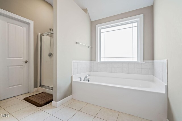 full bathroom with a stall shower, a garden tub, baseboards, and tile patterned floors