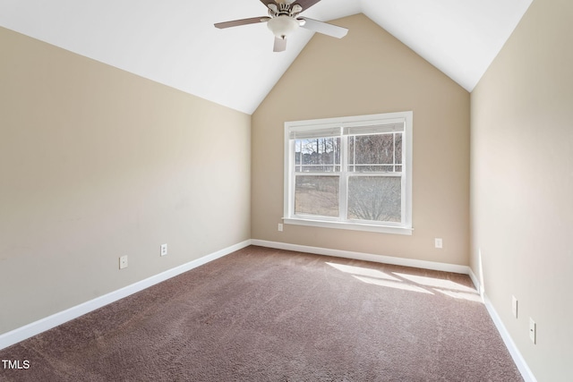 carpeted empty room with vaulted ceiling, a ceiling fan, and baseboards