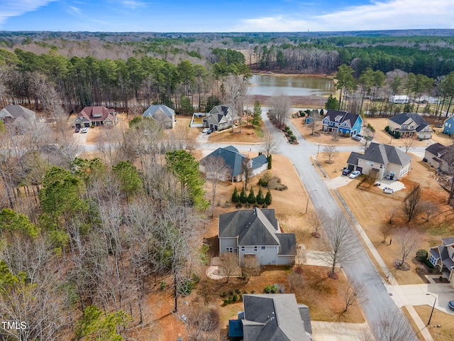 birds eye view of property featuring a water view and a view of trees