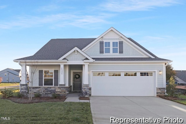 view of front of house with concrete driveway, a front lawn, roof with shingles, and stone siding