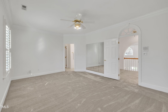 unfurnished bedroom with carpet, visible vents, baseboards, and ornamental molding