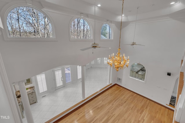 foyer entrance with a high ceiling, recessed lighting, wood finished floors, and crown molding