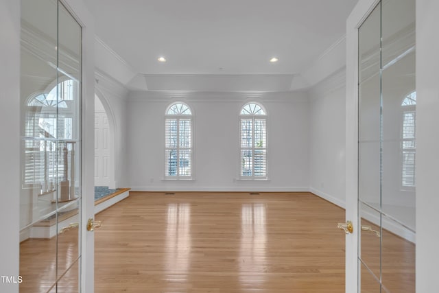 spare room with french doors, ornamental molding, light wood-type flooring, and baseboards