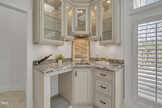 bar featuring marble finish floor, baseboards, and a sink