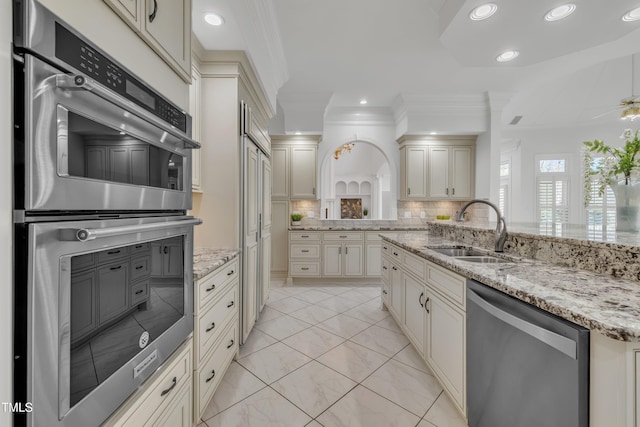 kitchen with recessed lighting, stainless steel appliances, a sink, backsplash, and crown molding