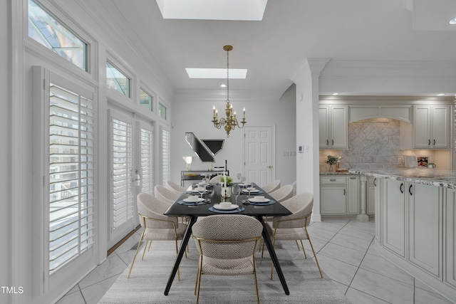 dining area featuring marble finish floor, ornamental molding, a skylight, and a notable chandelier