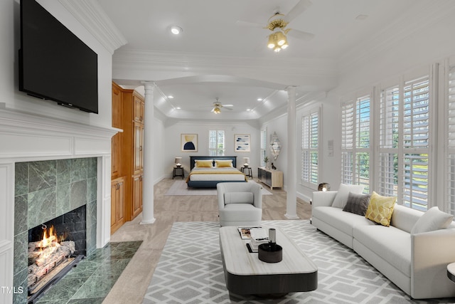 living area with arched walkways, a fireplace, and decorative columns