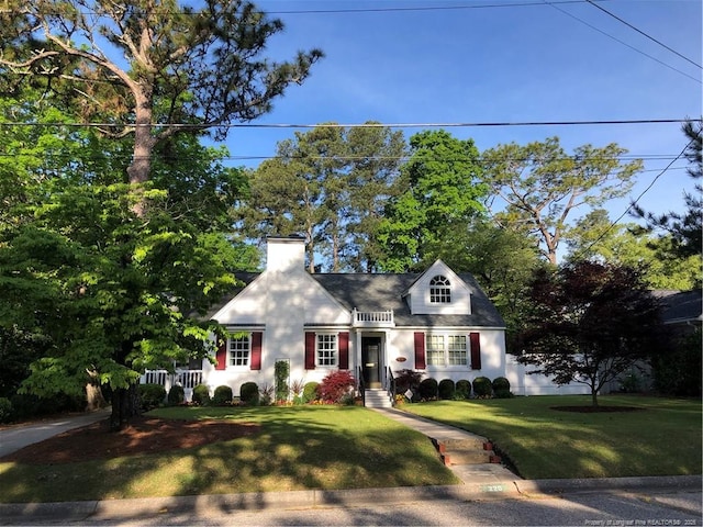 cape cod home with a chimney, fence, and a front lawn