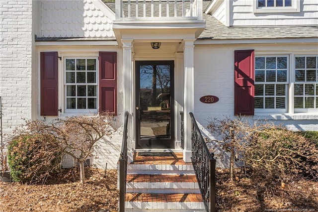 entrance to property featuring brick siding