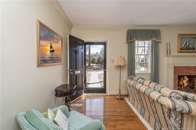 doorway to outside featuring ornamental molding, a premium fireplace, wood finished floors, and baseboards